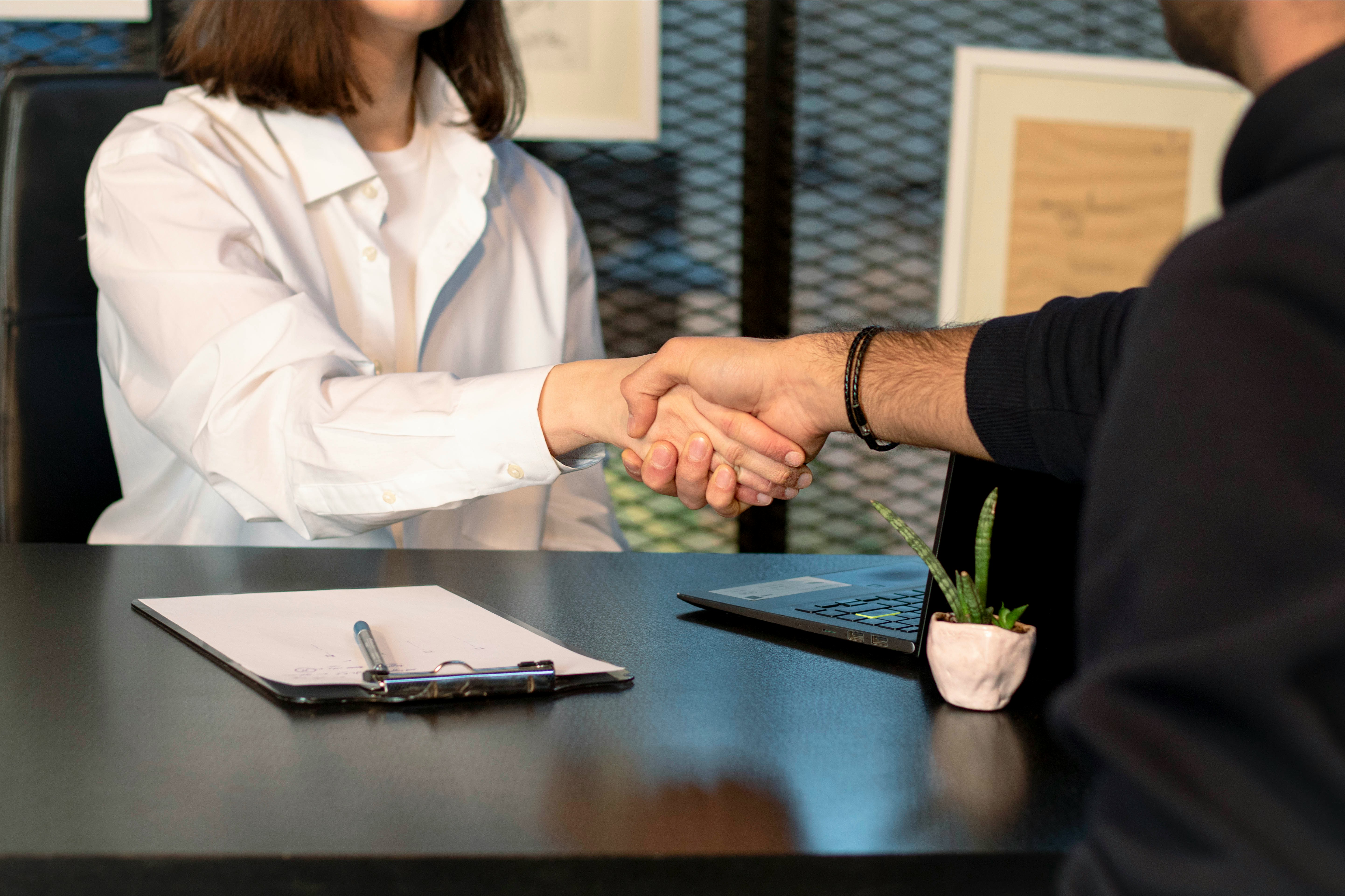 Aperto de m&atilde;os e pranchetas. Fechamento de contrato
