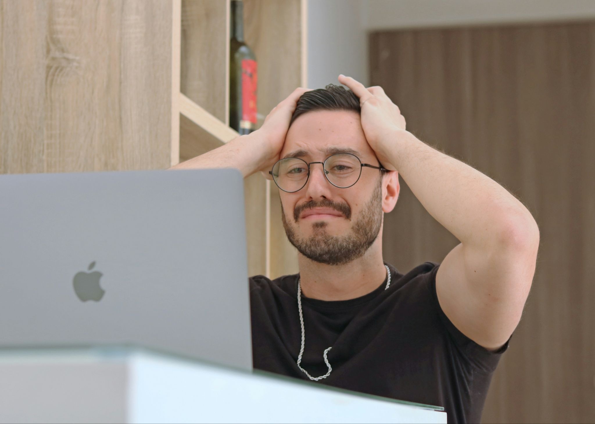 Homem olhando para notebook com cara de preocupação