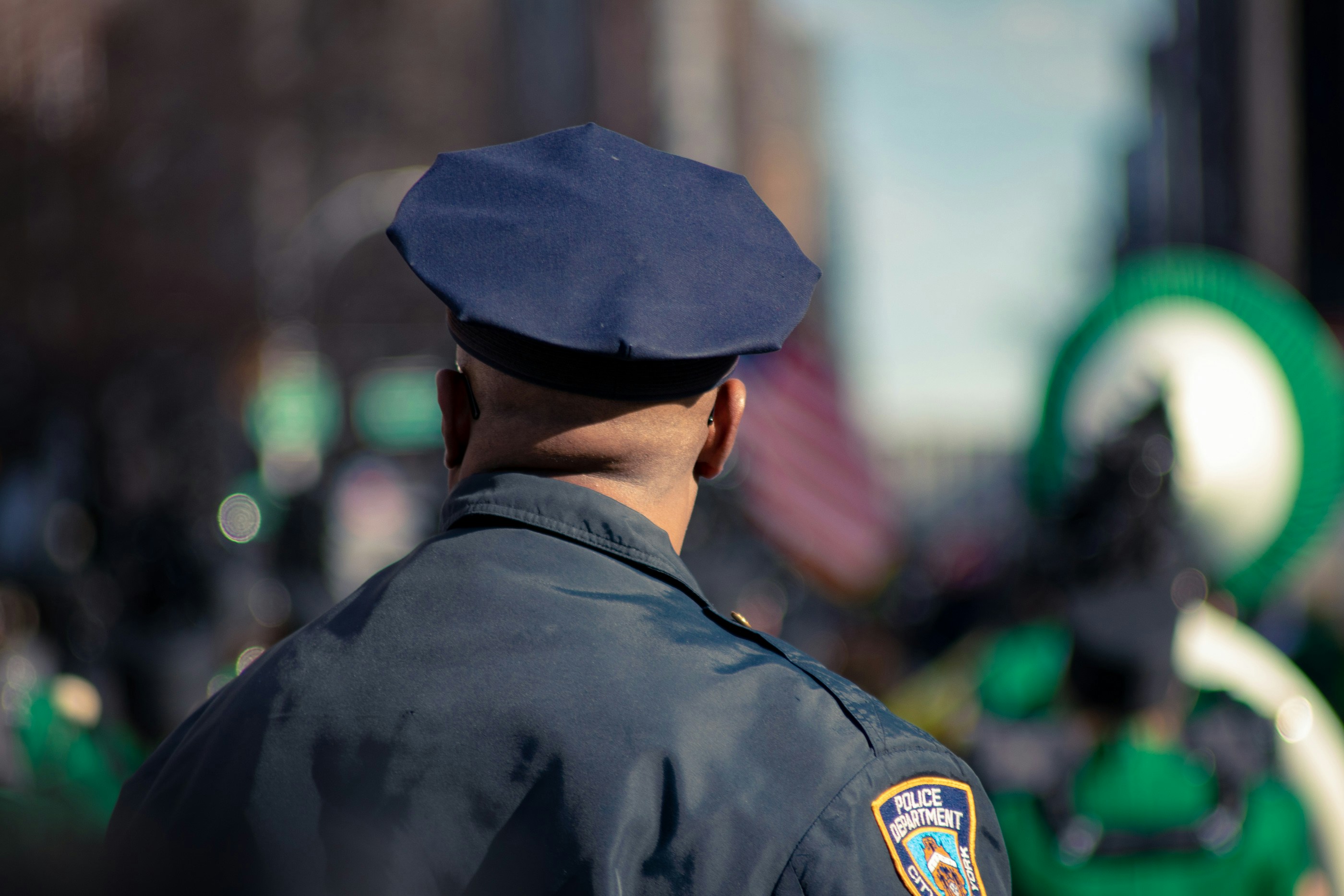 Guarda policial vestindo um uniforme azul e olhando na dire&ccedil;&atilde;o perpedicular &agrave; c&acirc;mera